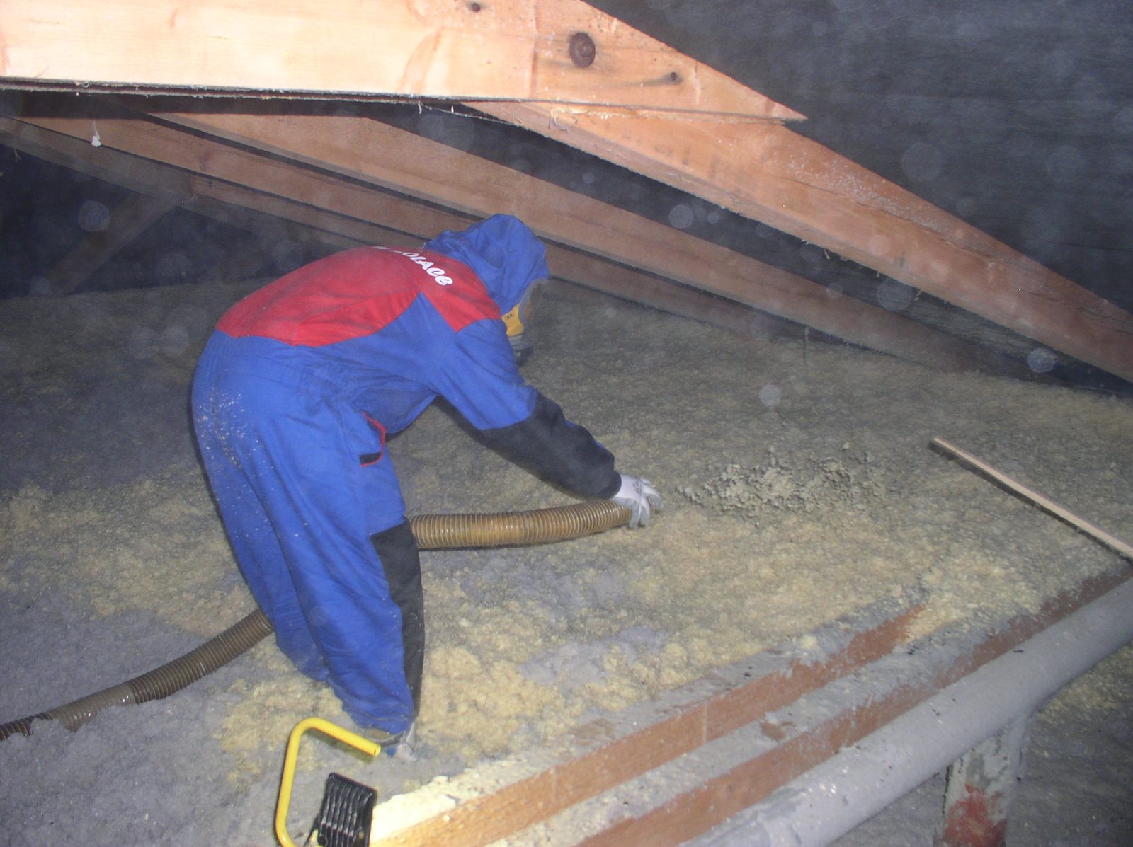 Technik fouká izolaci do konstrukce půdy